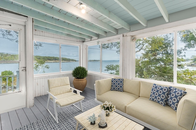 sunroom / solarium featuring a water view and beam ceiling