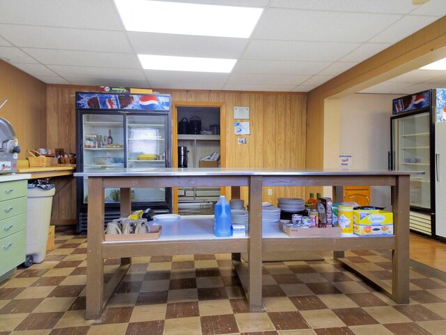 interior space featuring wood walls and a drop ceiling