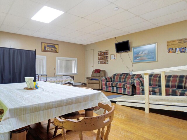 dining area with a paneled ceiling and wood-type flooring