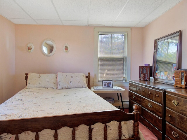 bedroom with a baseboard radiator and a paneled ceiling