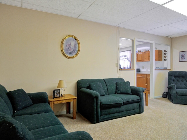 carpeted living room featuring a drop ceiling