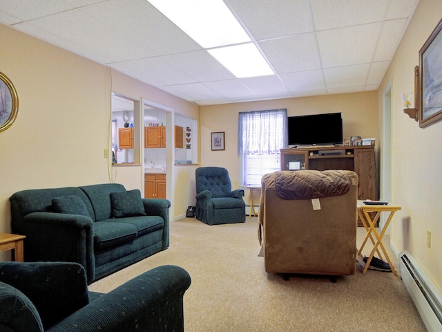 carpeted living room with a baseboard heating unit and a drop ceiling