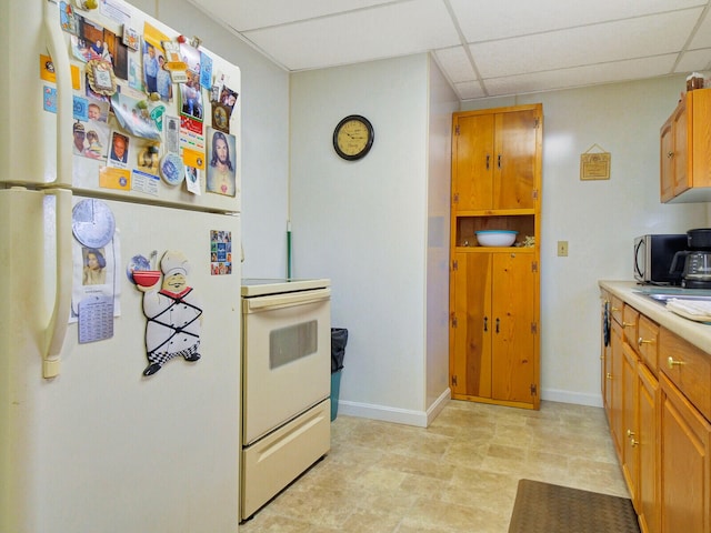 kitchen with white appliances and a paneled ceiling