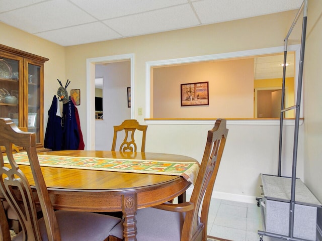 dining space with a drop ceiling