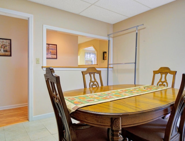 dining space with a paneled ceiling and light hardwood / wood-style floors