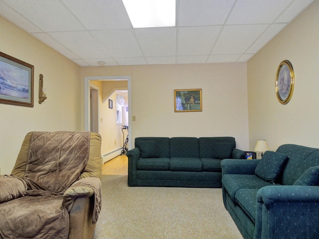 living room with baseboard heating, a paneled ceiling, and carpet flooring