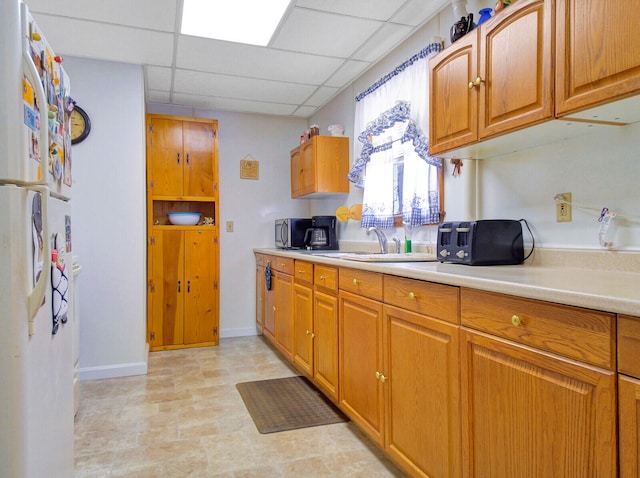 kitchen featuring a paneled ceiling and white fridge