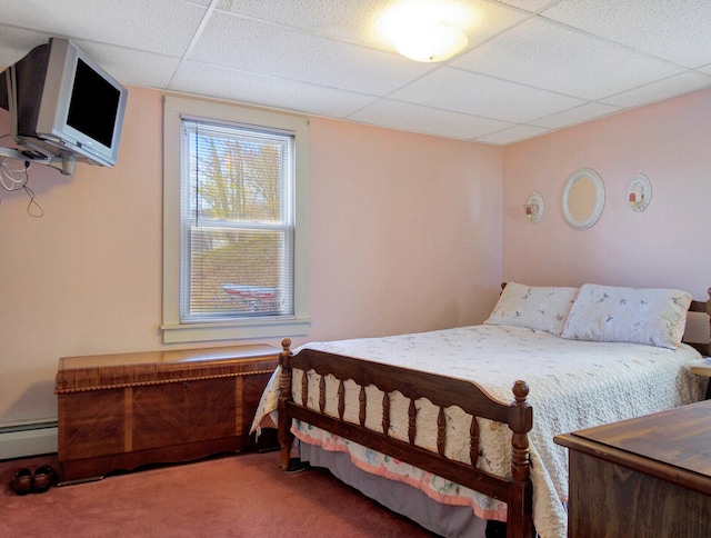 carpeted bedroom with a baseboard heating unit and a drop ceiling