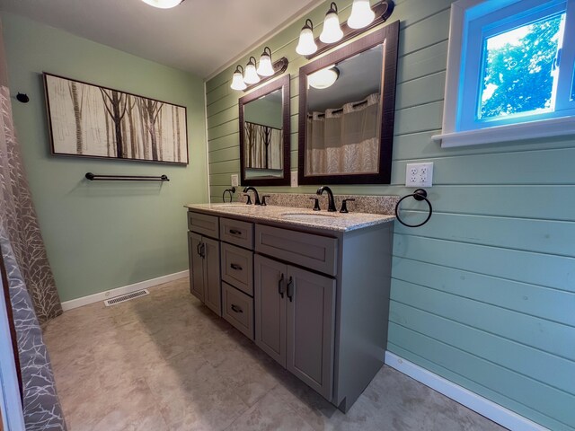 bathroom with vanity and wood walls