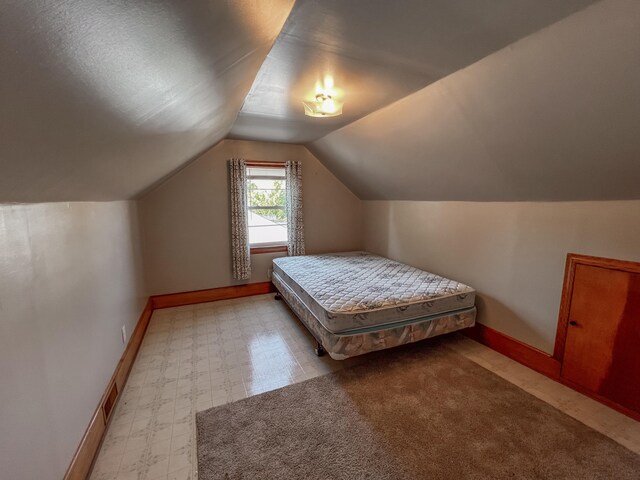 bedroom featuring vaulted ceiling and light colored carpet