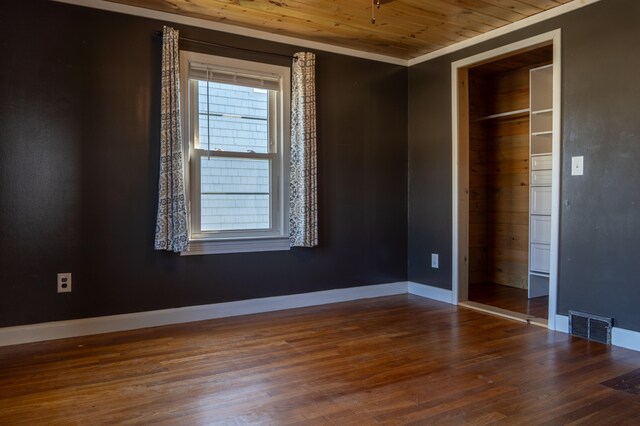 unfurnished bedroom featuring wooden ceiling, ornamental molding, hardwood / wood-style floors, and a closet