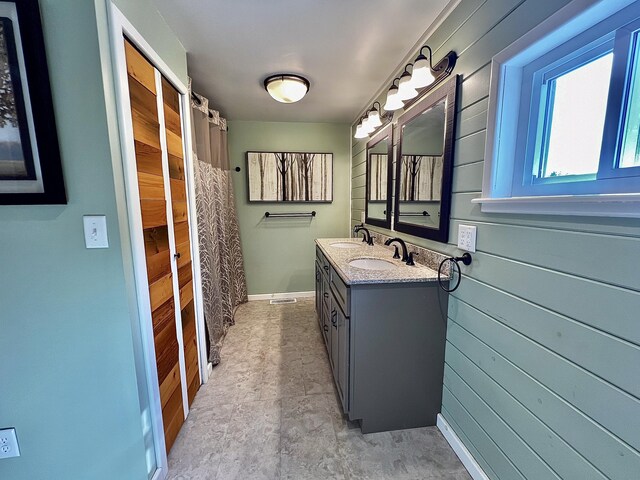 bathroom with vanity and wooden walls