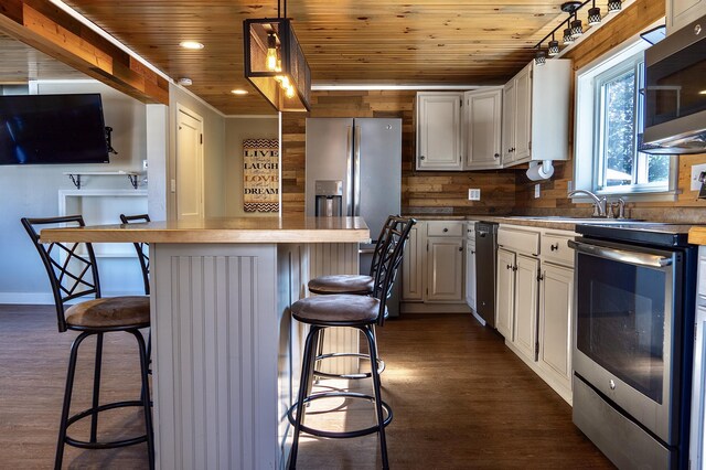 kitchen featuring a breakfast bar, stainless steel appliances, dark hardwood / wood-style floors, and sink