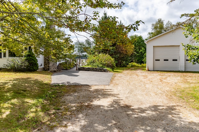 view of yard featuring a garage and an outbuilding