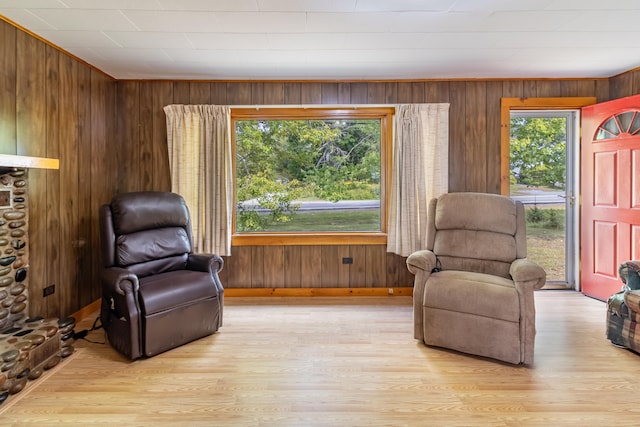 living area featuring wooden walls and light hardwood / wood-style floors