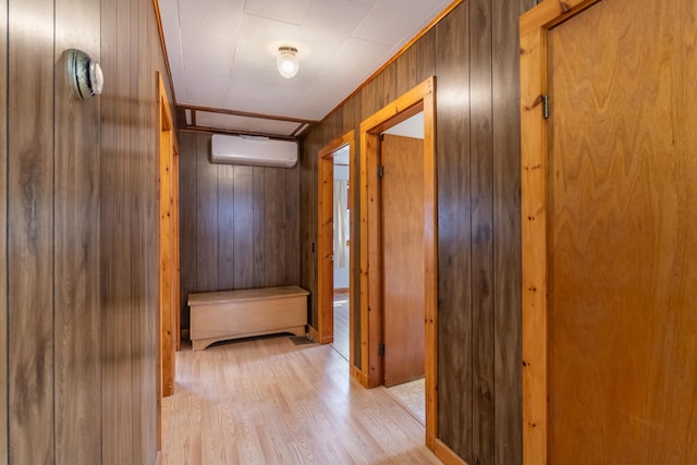 hall featuring wood walls, light wood-type flooring, and a wall unit AC