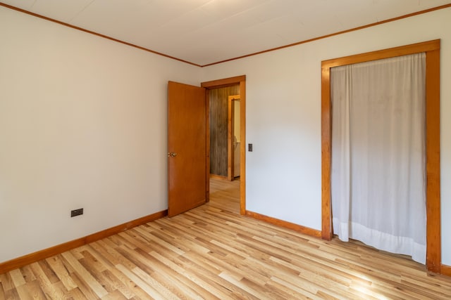 unfurnished bedroom with crown molding and light hardwood / wood-style flooring