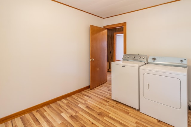 laundry area featuring ornamental molding, separate washer and dryer, and light wood-type flooring