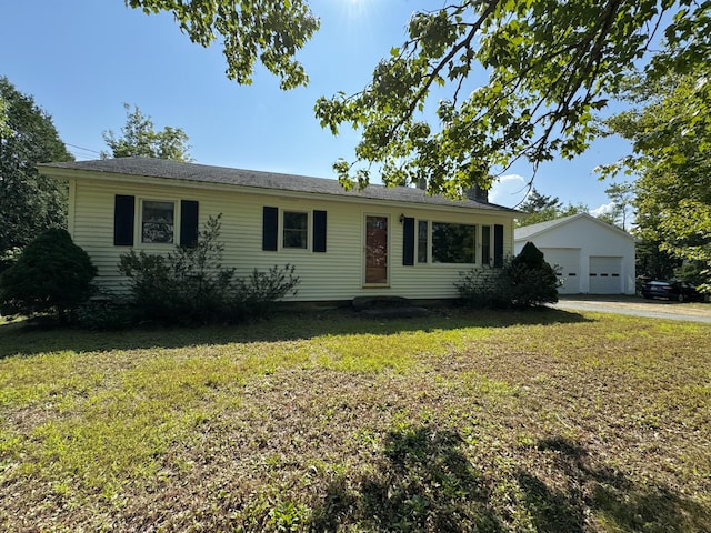 ranch-style home with a front yard, an outbuilding, and a garage