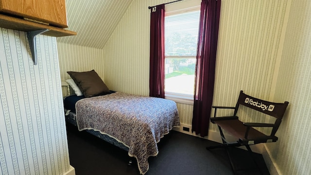 bedroom featuring wallpapered walls and lofted ceiling