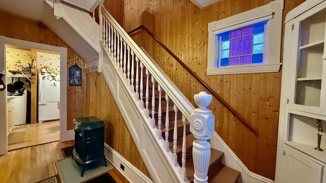 stairs featuring wooden walls and wood finished floors