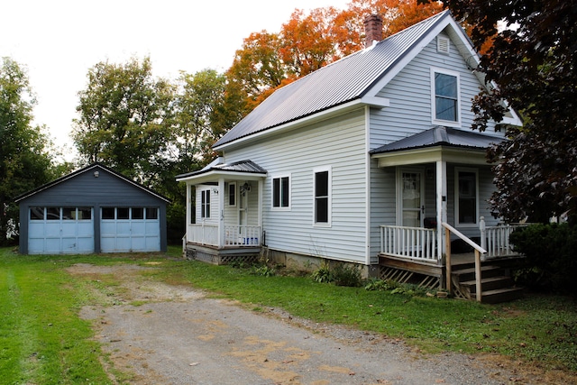 view of front of house with a front yard, covered porch, an outdoor structure, and a garage