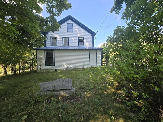 back of house featuring metal roof