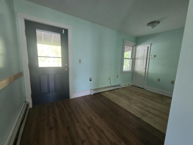 foyer entrance featuring a wealth of natural light, a baseboard heating unit, and wood finished floors