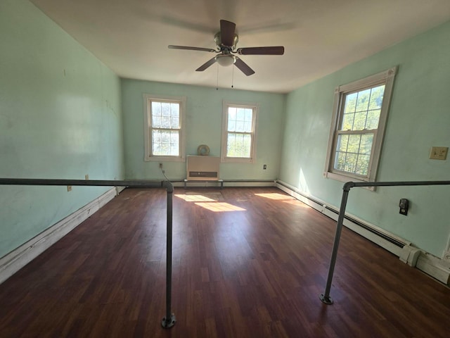 spare room featuring a healthy amount of sunlight, ceiling fan, and dark wood-type flooring