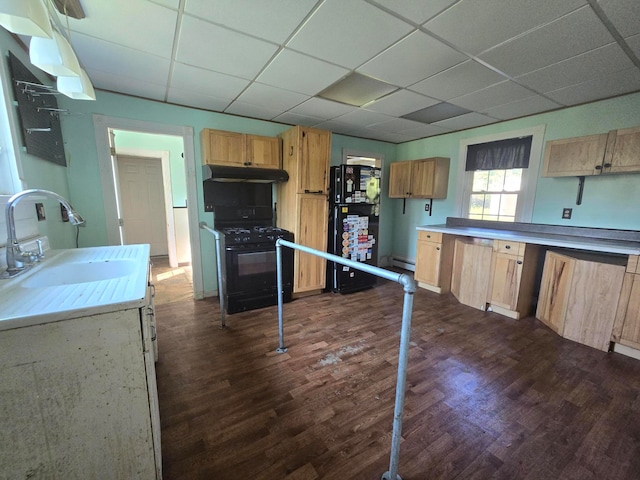 kitchen featuring black appliances, dark hardwood / wood-style flooring, sink, and a drop ceiling