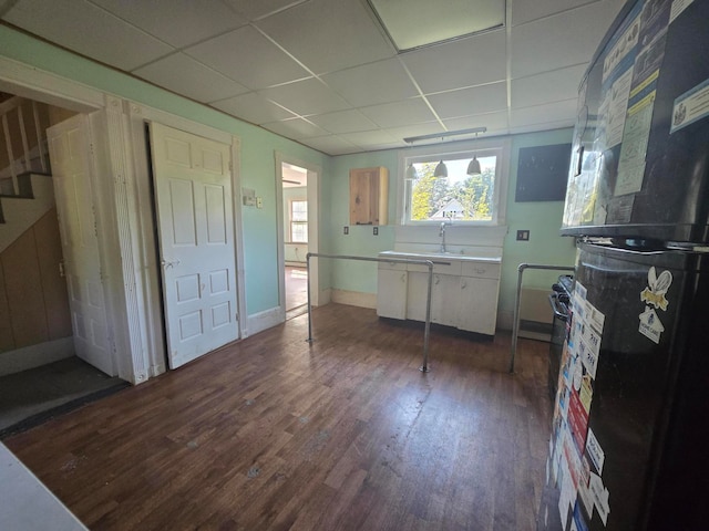 kitchen with a paneled ceiling, dark hardwood / wood-style floors, and black fridge