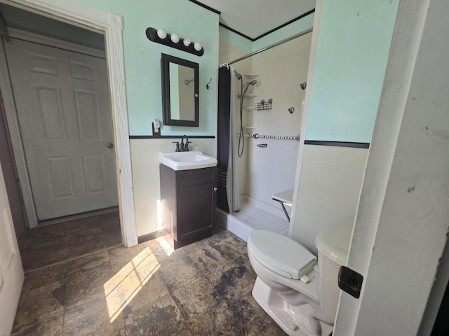 full bath featuring vanity, baseboards, a stall shower, stone finish flooring, and toilet