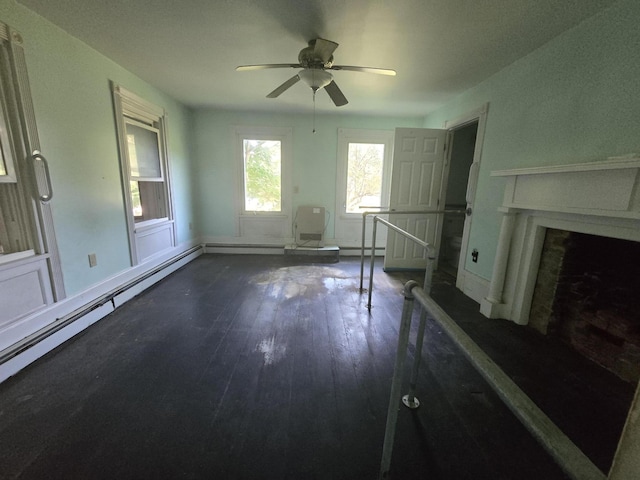 unfurnished living room featuring a fireplace with raised hearth, wood finished floors, baseboards, baseboard heating, and ceiling fan