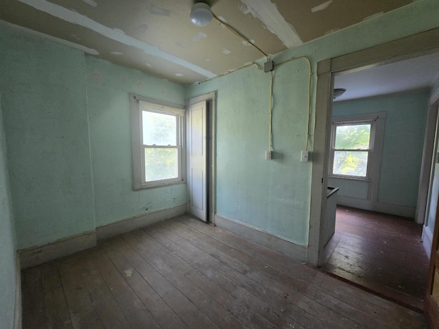 unfurnished room with baseboards and hardwood / wood-style floors