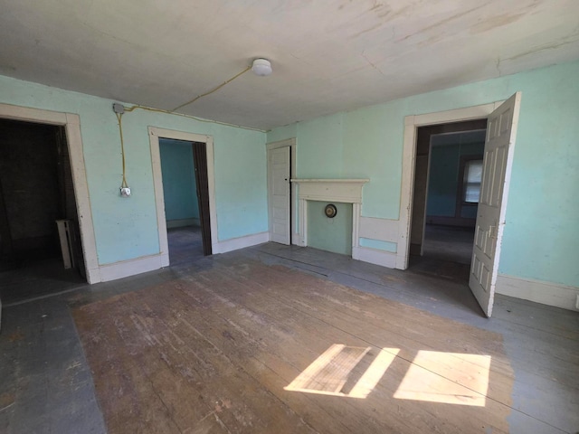 unfurnished living room featuring radiator heating unit and hardwood / wood-style floors