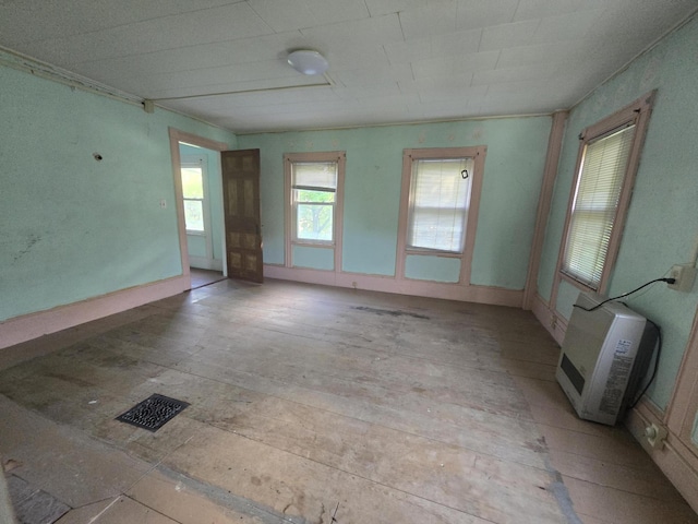 empty room with heating unit and visible vents