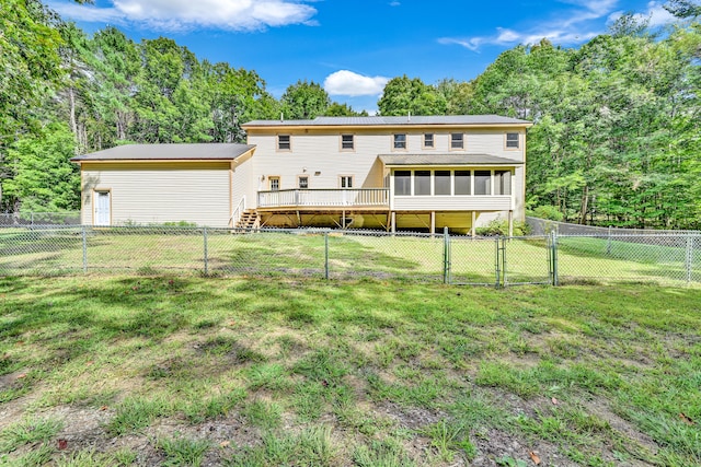 back of house with a lawn, a sunroom, and a deck