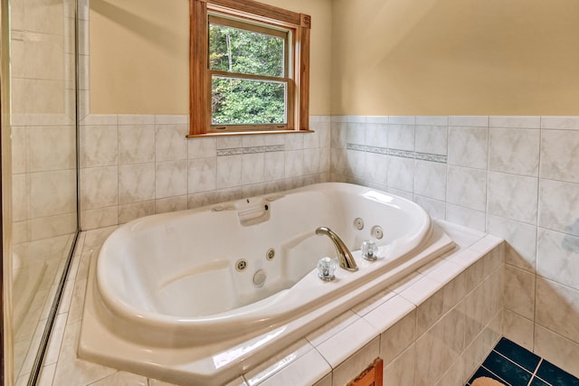 bathroom featuring tile patterned flooring and tiled tub