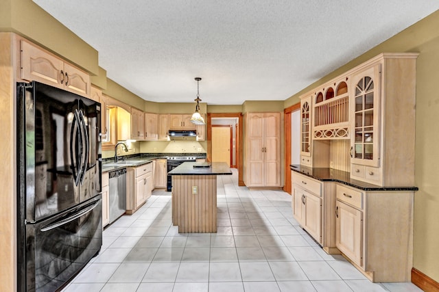 kitchen featuring a textured ceiling, a kitchen island, dishwasher, light brown cabinetry, and black fridge