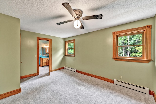 carpeted spare room featuring plenty of natural light, ceiling fan, and a baseboard radiator