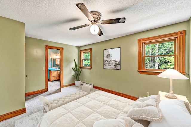 carpeted bedroom with a baseboard radiator, ensuite bath, ceiling fan, and multiple windows