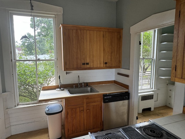 kitchen with appliances with stainless steel finishes, radiator, a healthy amount of sunlight, and sink