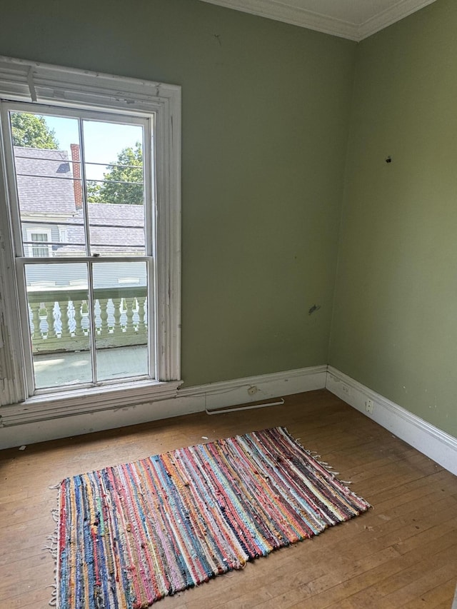 spare room with hardwood / wood-style floors and ornamental molding