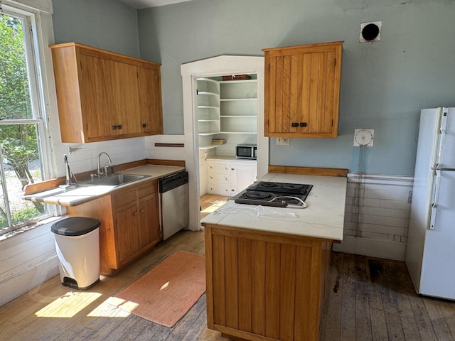 kitchen with stainless steel appliances, a kitchen island, light hardwood / wood-style floors, and sink