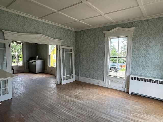 spare room with radiator heating unit, hardwood / wood-style floors, and coffered ceiling