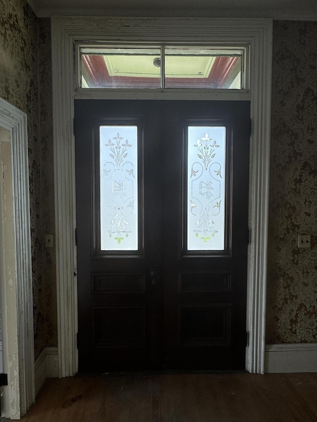 foyer entrance with hardwood / wood-style floors and french doors