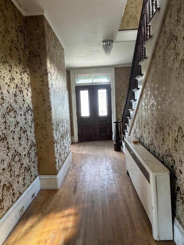 foyer featuring radiator, french doors, and wood-type flooring