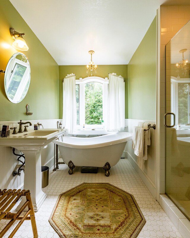 bathroom featuring a notable chandelier, shower with separate bathtub, and tile patterned floors