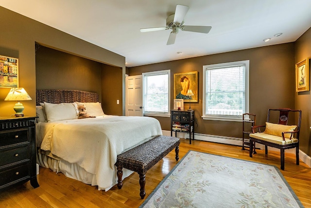 bedroom with a ceiling fan, baseboards, and wood finished floors