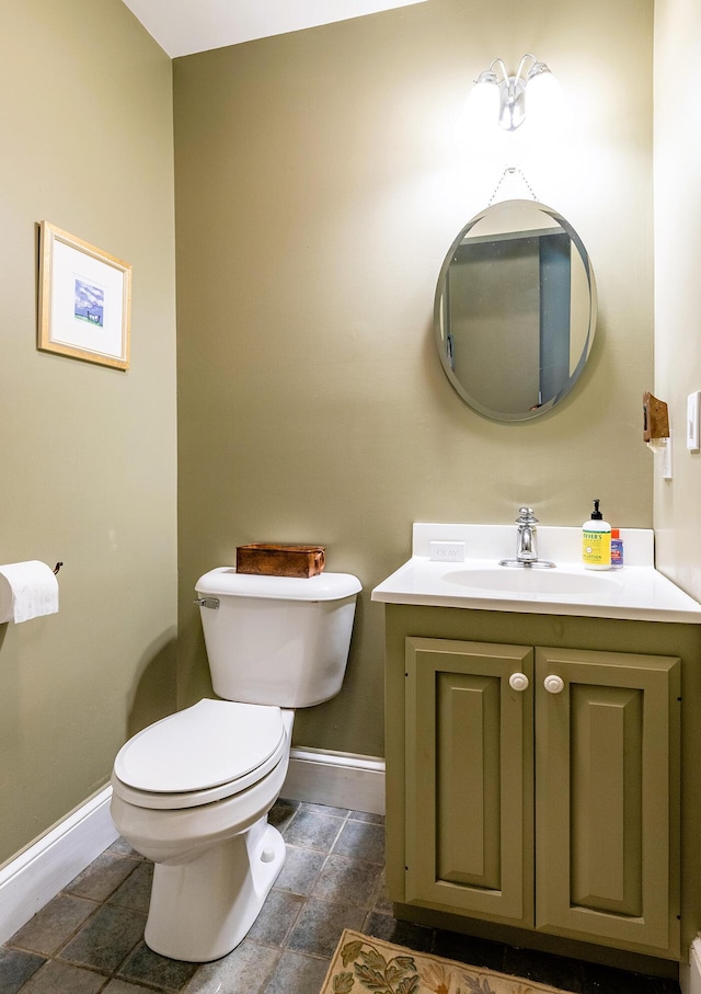 bathroom featuring vanity, toilet, and baseboards